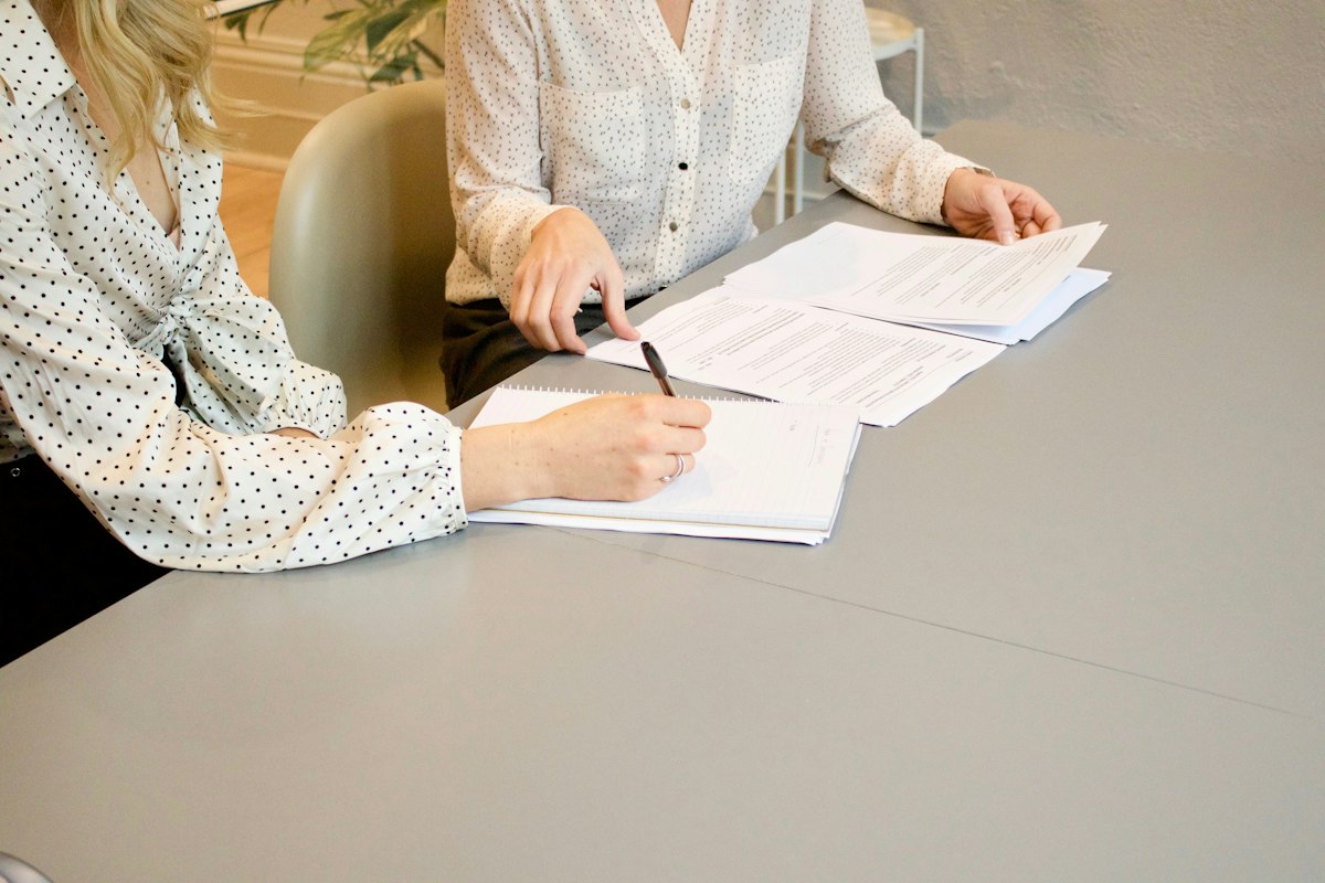 Two people signing documents together