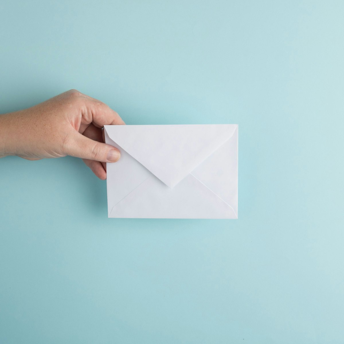 Person holding a white envelope