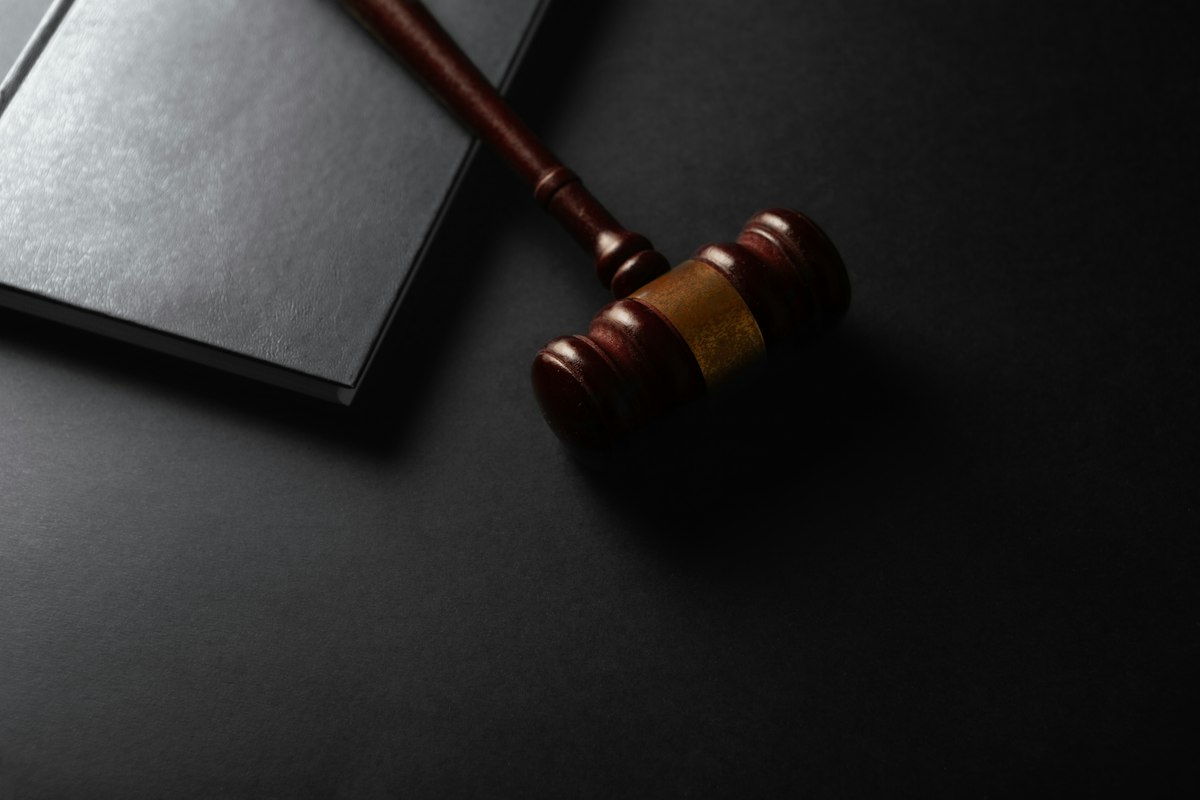 Wooden gavel resting beside a law book